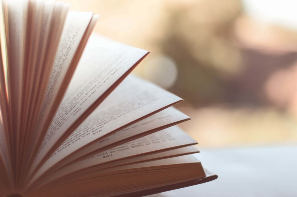 Open book on table with pages standing up.