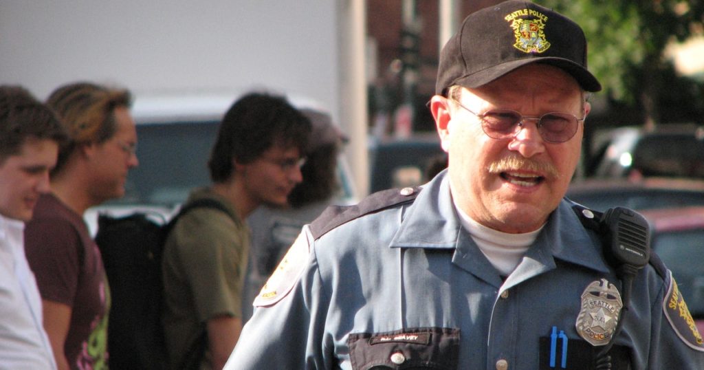 Seattle Police officer standing in front of group of people.