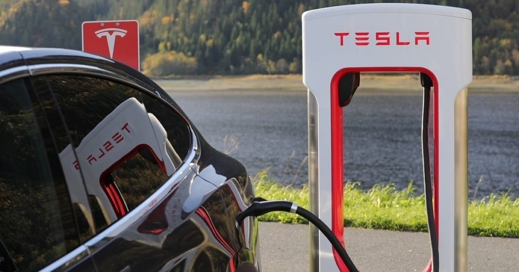 A Tesla electric car charging at a power station.